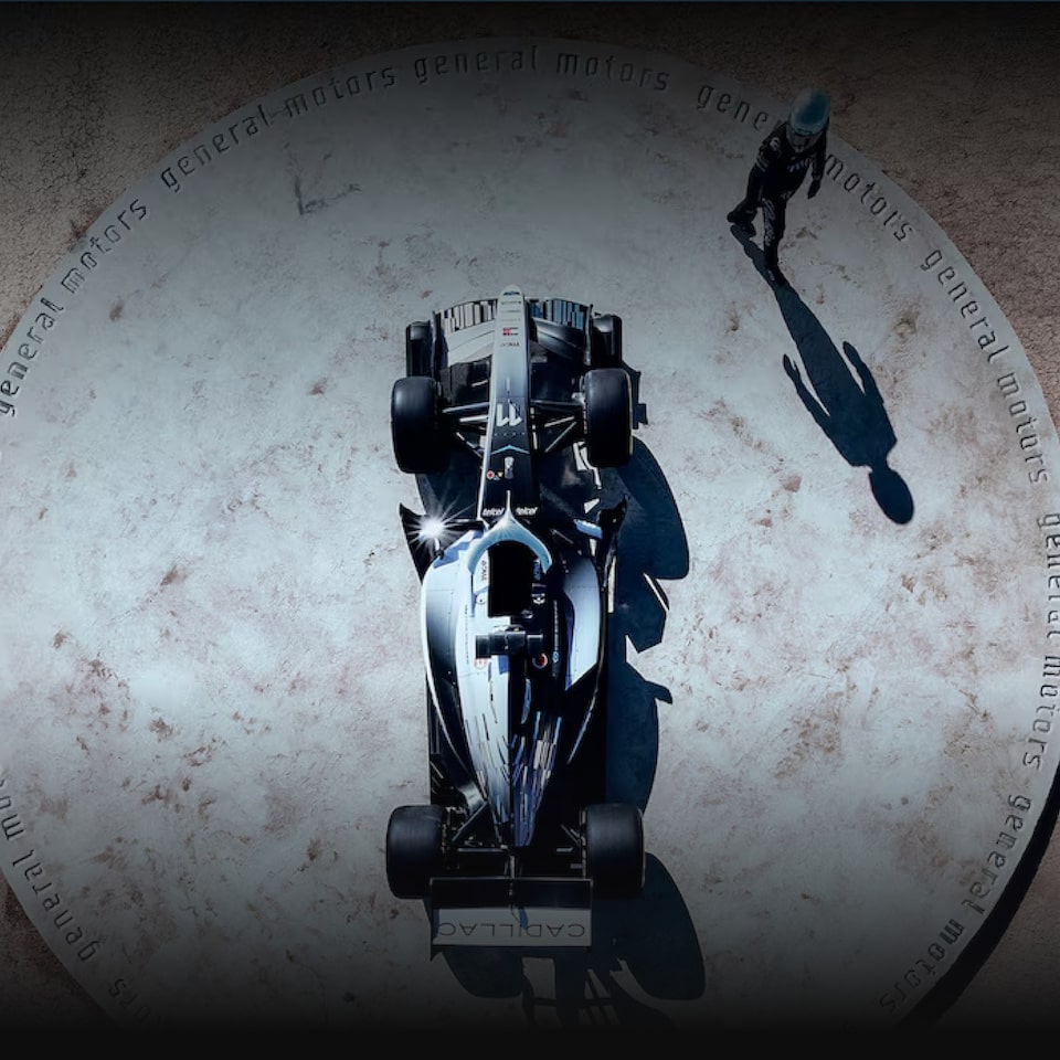 Carro da Cadillac Formula 1 Team visto de cima ladeado por piloto diferenciado.