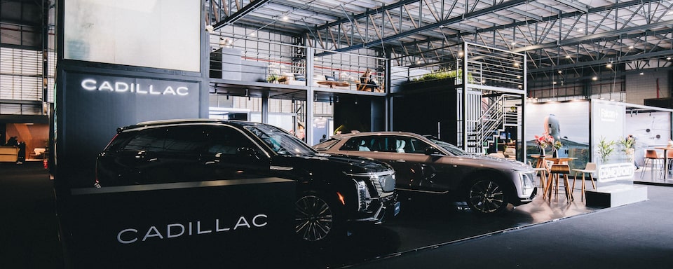 Stand da Cadillac dentro do Aviation Show, exibindo os dois modelos da marca disponíveis no Brasil.