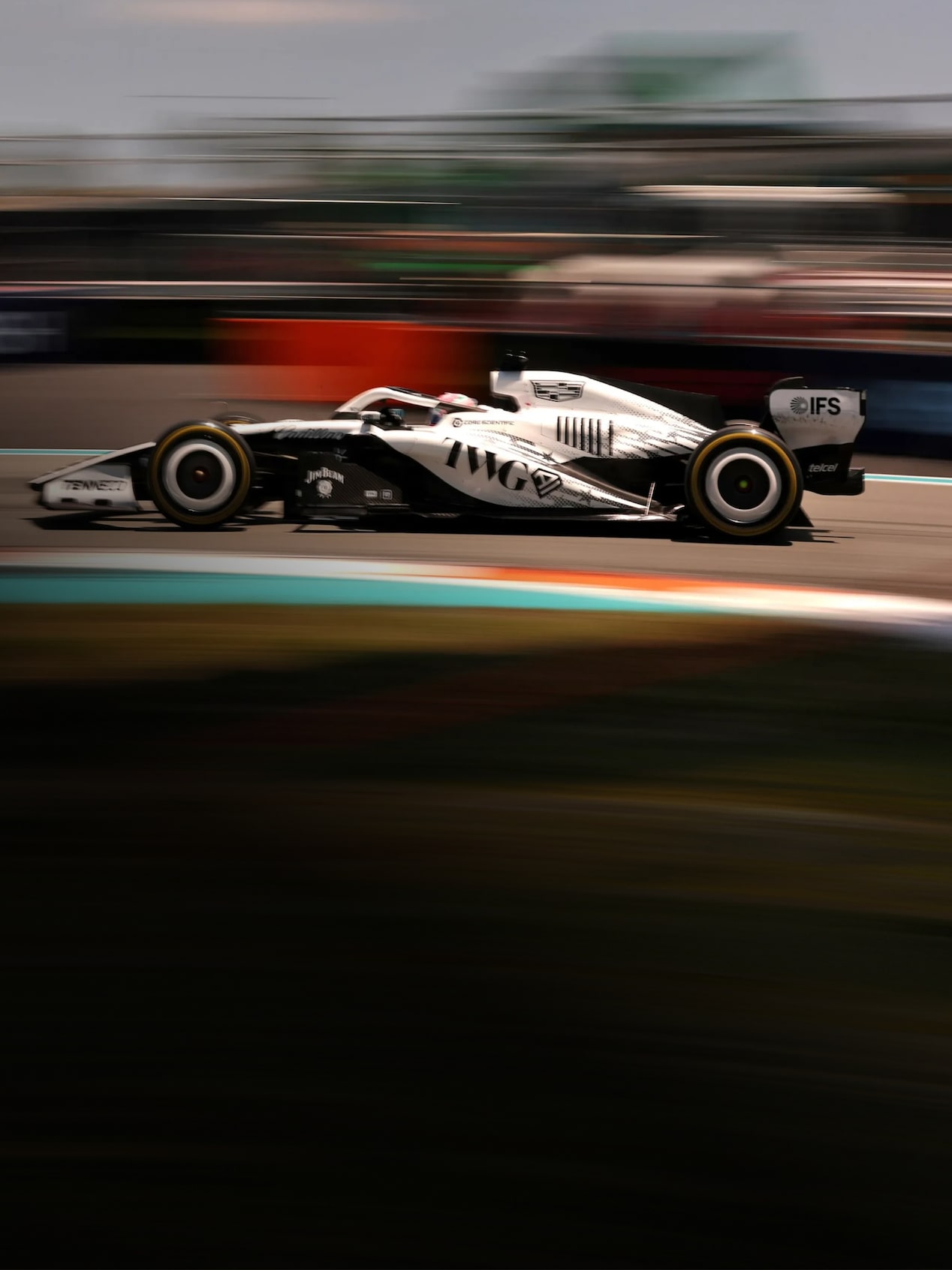 Carro da Cadillac Formula 1 Team em imagem ambientada numa pista de corrida.