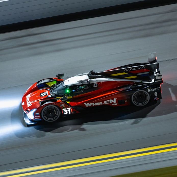 Veículo Cadillac vermelho em imagem ambientada na pista para ilustrar a história da marca nas pistas.
