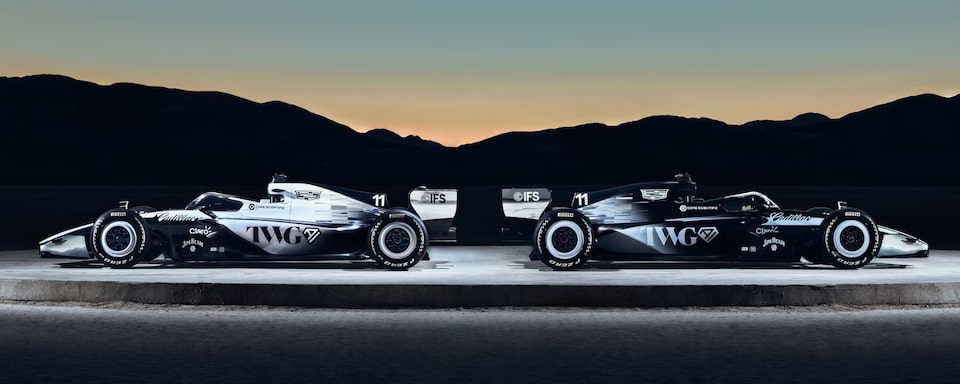 Veículos da Cadillac F1 Team dispostos ao crepúsculo.