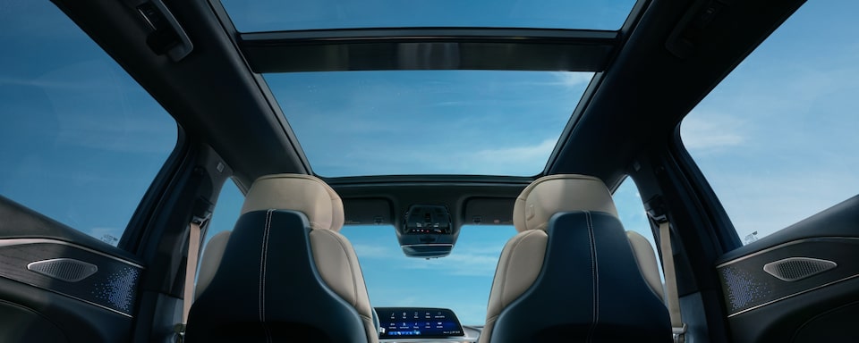 Visão interior de um SUV Cadillac, retratando o luxo inerente à marca. Destaque para o teto solar panorâmico.