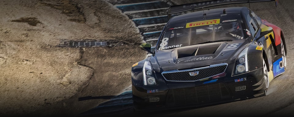 Cadillac ATS-V.R em ação descendo a pista em um ambiente montanhoso.