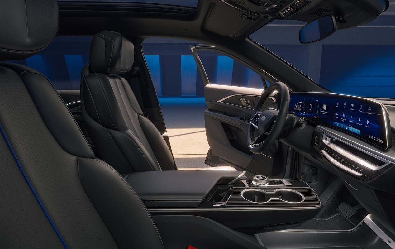  Interior de veículo Cadillac com bancos em couro, teto solar, painel digital, central multimídia integrada e acabamento premium.