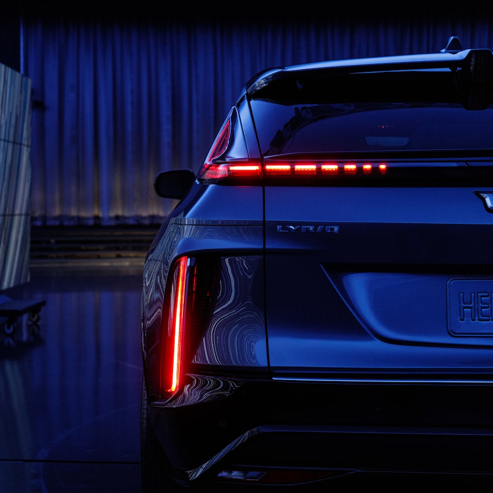 Parte traseira do moderno Cadillac Lyriq, exibindo sua impressionante tecnologia LED em um ambiente com luzes baixas.