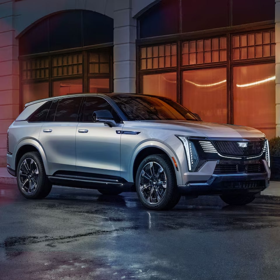 Cadillac Lyriq posicionado em 3/4 na imagem com seu design impactante, destacando-se em um ambiente urbano.