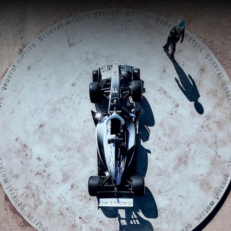 Carro da Cadillac Formula 1 Team visto de cima ladeado por piloto diferenciado.