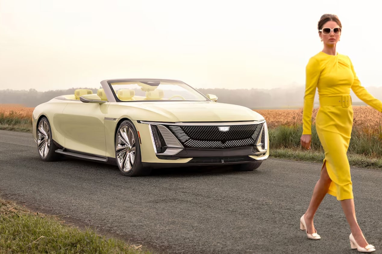 Mulher vestida em amarelo caminhando ao lado do conversível elétrico Cadillac Sollei, capturando estilo e dinamismo.