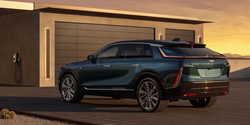 Cadillac LYRIQ estacionado em residência com carregador residencial, destacando design sofisticado, mobilidade elétrica e experiência premium de recarga em casa.