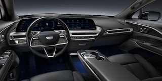 Mulher dirigindo o Cadillac LYRIQ, com o interior do veículo em destaque e paisagem ao entardecer ao fundo.