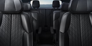 Detalhe do acabamento interno da porta de um veículo Cadillac, com revestimento premium, linhas sofisticadas e acabamento em tons escuros.