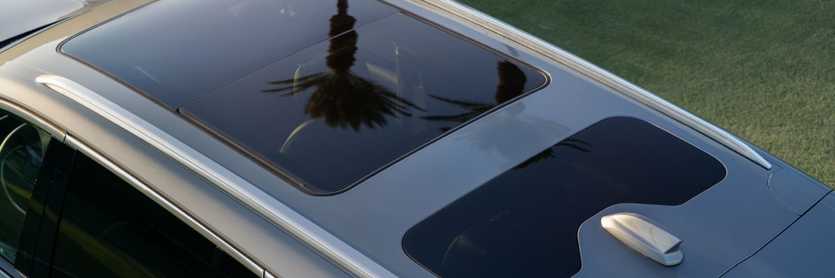 Vista superior de um veículo Cadillac destacando o teto solar de vidro, com acabamento moderno.